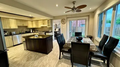 a kitchen with a table and chairs and a dining room at Massive Luxury Retreat with Gym, Sauna, Games and More in Mississauga
