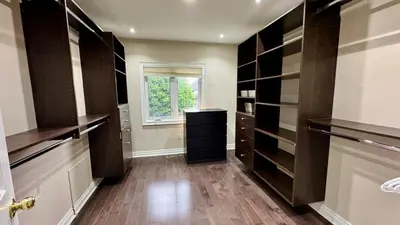 a walk in closet with black cabinets and a window at Massive Luxury Retreat with Gym, Sauna, Games and More in Mississauga