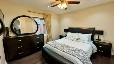 a bedroom with a bed with a dresser and a mirror at Massive Luxury Retreat with Gym, Sauna, Games and More in Mississauga