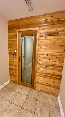 a room with a wooden wall with a mirror at Massive Luxury Retreat with Gym, Sauna, Games and More in Mississauga