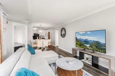 a living room with a white couch and a flat screen tv at Sky Retreat | 2BR-2BA High Floor | 180° City View in Mississauga