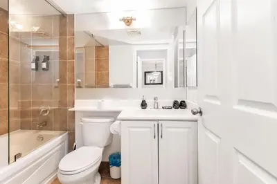 a bathroom with a toilet and a sink and a tub at Sky Retreat | 2BR-2BA High Floor | 180° City View in Mississauga