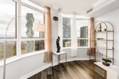 a living room with large windows and a statue on a table at Sky Retreat | 2BR-2BA High Floor | 180° City View in Mississauga
