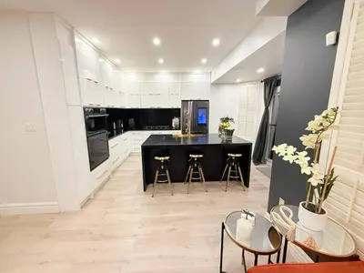 a kitchen with a black counter and stools at Welcome to Your Home Away From Home! in Mississauga