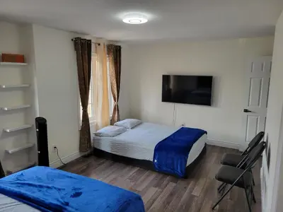 a bedroom with two beds and a flat screen tv at Luxury Suite - Master Bedroom in Niagara Falls