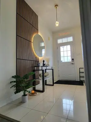 a hallway with a table and a mirror and a door at Luxury Suite - Master Bedroom in Niagara Falls