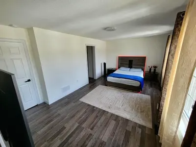 a bedroom with a bed and a wooden floor at Luxury Suite - Master Bedroom in Niagara Falls