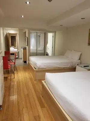 a hotel room with two beds and a table at Dragon Gate Inn in Toronto