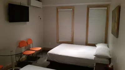 a room with a bed and a table and chairs at Dragon Gate Inn in Toronto