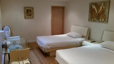 a hotel room with two beds and a table and chairs at Dragon Gate Inn in Toronto