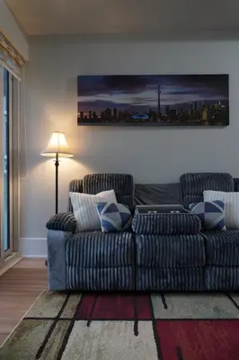 a living room with a couch and a lamp at Downtown Toronto Condo with CN Tower View in Toronto