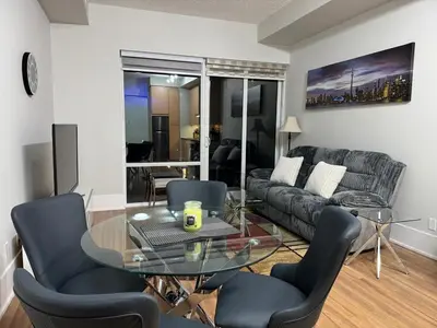 a living room with a glass table and a couch at Downtown Toronto Condo with CN Tower View in Toronto
