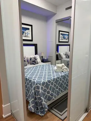 a bedroom with a bed and a large mirror at Downtown Toronto Condo with CN Tower View in Toronto