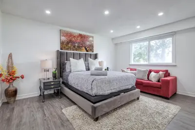 a bedroom with a bed and a red couch at The Rosewood 1 Bedroom Basement Retreat in Vaughan