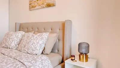 a bedroom with a bed and a table with a lamp at Luxury 1 BR and Den Near CN Tower in Toronto