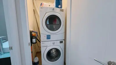 a washing machine and a washer in a room at Luxury 1 BR and Den Near CN Tower in Toronto