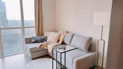 a living room with a couch and a large window at Luxury 1 BR and Den Near CN Tower in Toronto