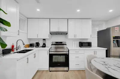 a kitchen with white cabinets and a black oven at Your Luxurious Caledon Escape in Brampton