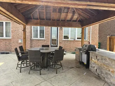 a patio with a table and chairs and a grill at Your Luxurious Caledon Escape in Brampton