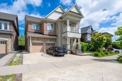 a house with a car parked in front of it at Your Luxurious Caledon Escape in Brampton