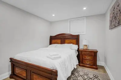 a bedroom with a bed with a wooden bed frame and a nightstand at Your Luxurious Caledon Escape in Brampton