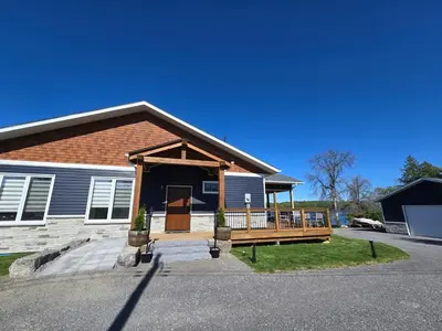 a house with a porch and a deck at Wheel chair Access, Private Boat Launch in Roseneath