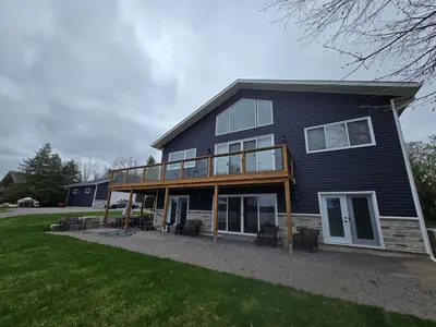 a house with a deck on the side of it at Wheel chair Access, Private Boat Launch in Roseneath