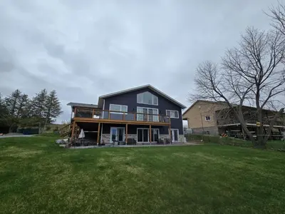 a large black house on a grass field at Wheel chair Access, Private Boat Launch in Roseneath