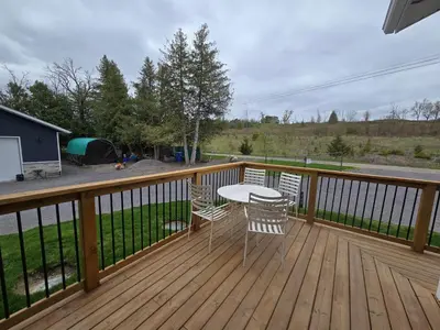 a wooden deck with a table and chairs on it at Wheel chair Access, Private Boat Launch in Roseneath
