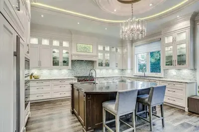 a kitchen with a large island with chairs and a chandelier at Elegant Home with Yard and Comforts in Richmond Hill