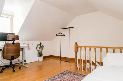 a bedroom with a bed and a desk with a computer at The Parkdale Cottage in Toronto
