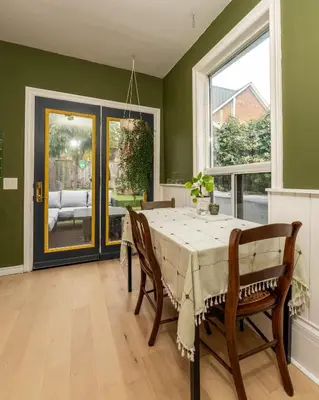 a dining room with a table and chairs and a window at The Parkdale Cottage in Toronto