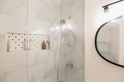 a bathroom with a shower with a glass door at The Parkdale Cottage in Toronto