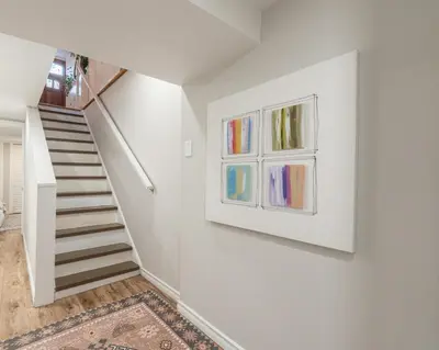 a staircase in a house with a painting on the wall at The Parkdale Cottage in Toronto