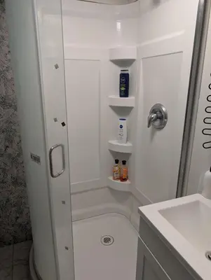 a white bathroom with a shower and a sink at Cozy Bachelor Unit in Guelph
