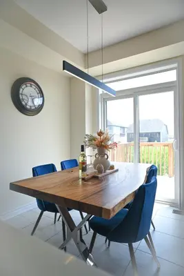 a dining room with a wooden table and blue chairs at Modern 3Bed Home 10 Mins to Niagra Falls in Thorold