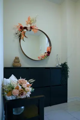 a mirror on a wall with flowers on a dresser at Modern 3Bed Home 10 Mins to Niagra Falls in Thorold