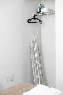 a white chair sitting in a corner of a room at Classy and Luxury 2 bedroom apartment 5 mins to Dundas Square in Toronto