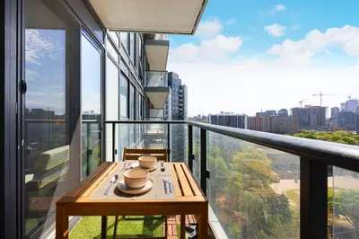 a balcony with a table with a view of a city at Classy and Luxury 2 bedroom apartment 5 mins to Dundas Square in Toronto