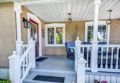 a front porch with white railings and a white railing at Matisse B&B in Niagara on the Lake