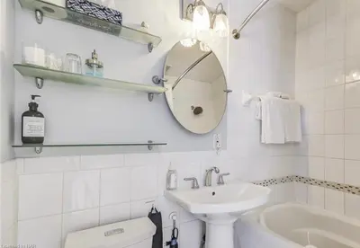 a bathroom with a sink and a toilet and a mirror at Matisse B&B in Niagara on the Lake