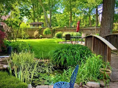 a garden with a table and chairs in a yard at Matisse B&B in Niagara on the Lake