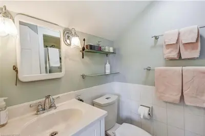 a white bathroom with a sink and a toilet at Matisse B&B in Niagara on the Lake