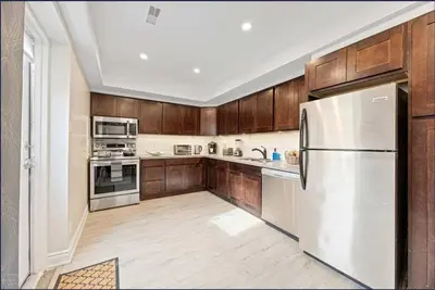 a kitchen with wooden cabinets and a white refrigerator at Casa Hotel Contemporary 2BR Suite w Patio & BBQ in Toronto