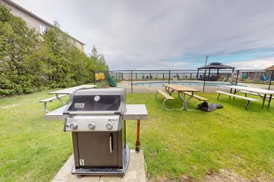 a barbecue grill and picnic tables in a park at The Driftwood Deck in Wasaga Beach