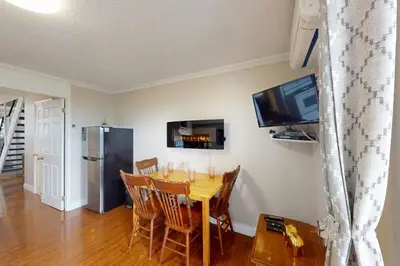 a dining room with a table and a tv at The Driftwood Deck in Wasaga Beach