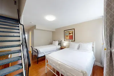 a hotel room with two beds and a staircase at The Driftwood Deck in Wasaga Beach