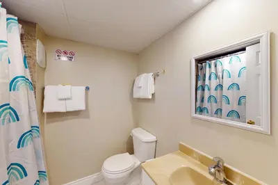 a bathroom with a toilet and a sink and a window at The Driftwood Deck in Wasaga Beach