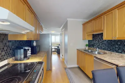 a kitchen with wooden cabinets and a stove top oven at The Driftwood Deck 5A in Wasaga Beach