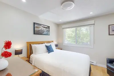 a bedroom with a white bed and a window at The Driftwood Deck 5A in Wasaga Beach